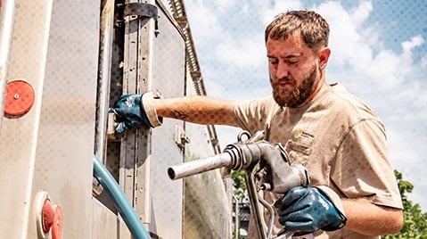 farmward employee filling tank with fuel
