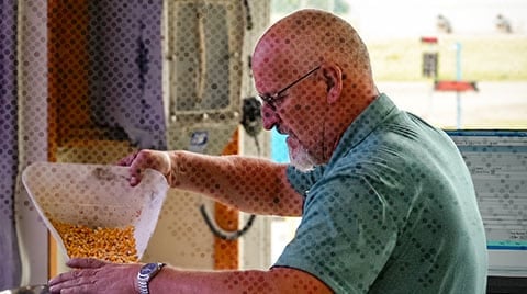 farmward employee testing corn in scale house