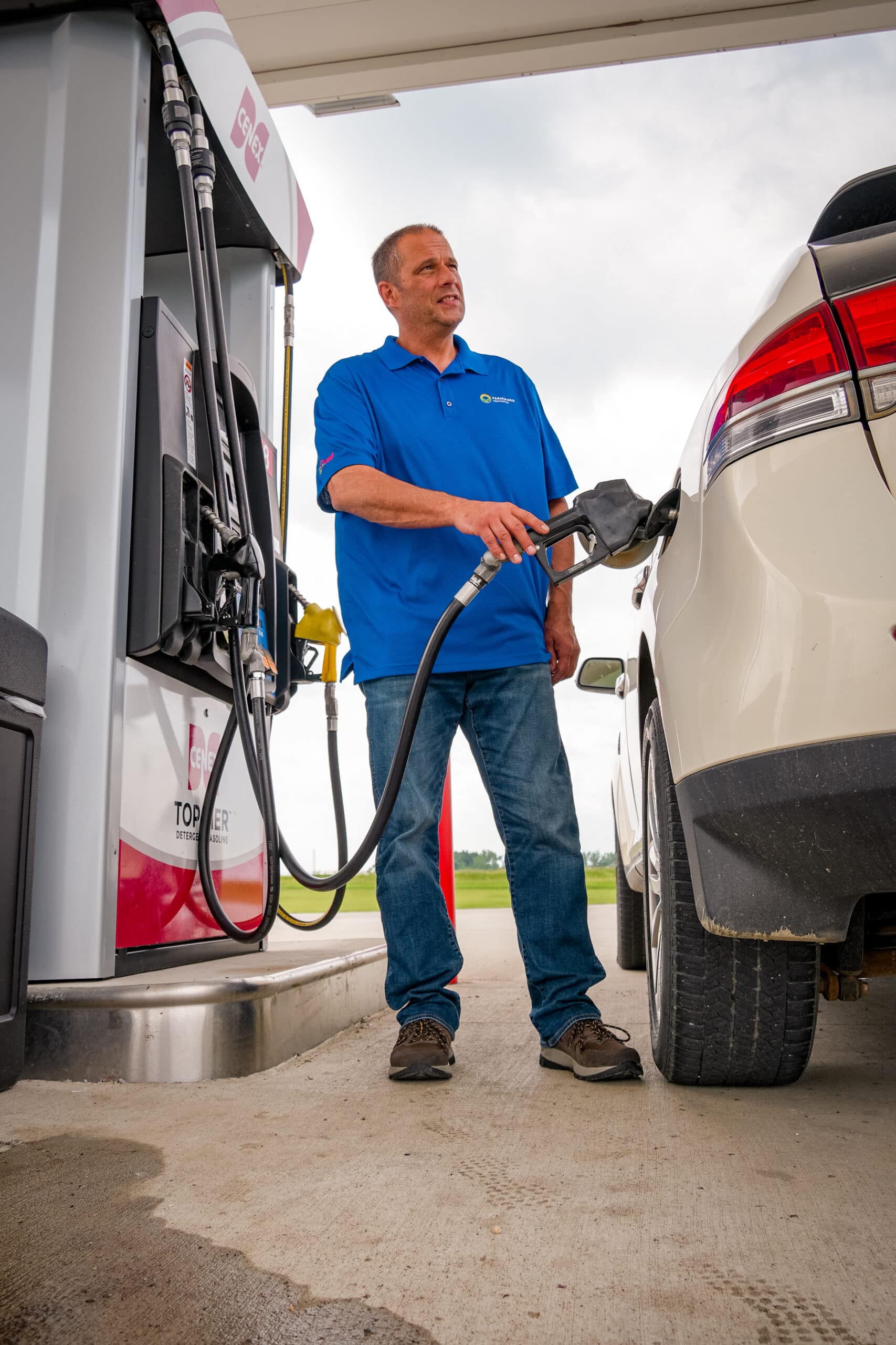 farmward employee filling white car with fuel