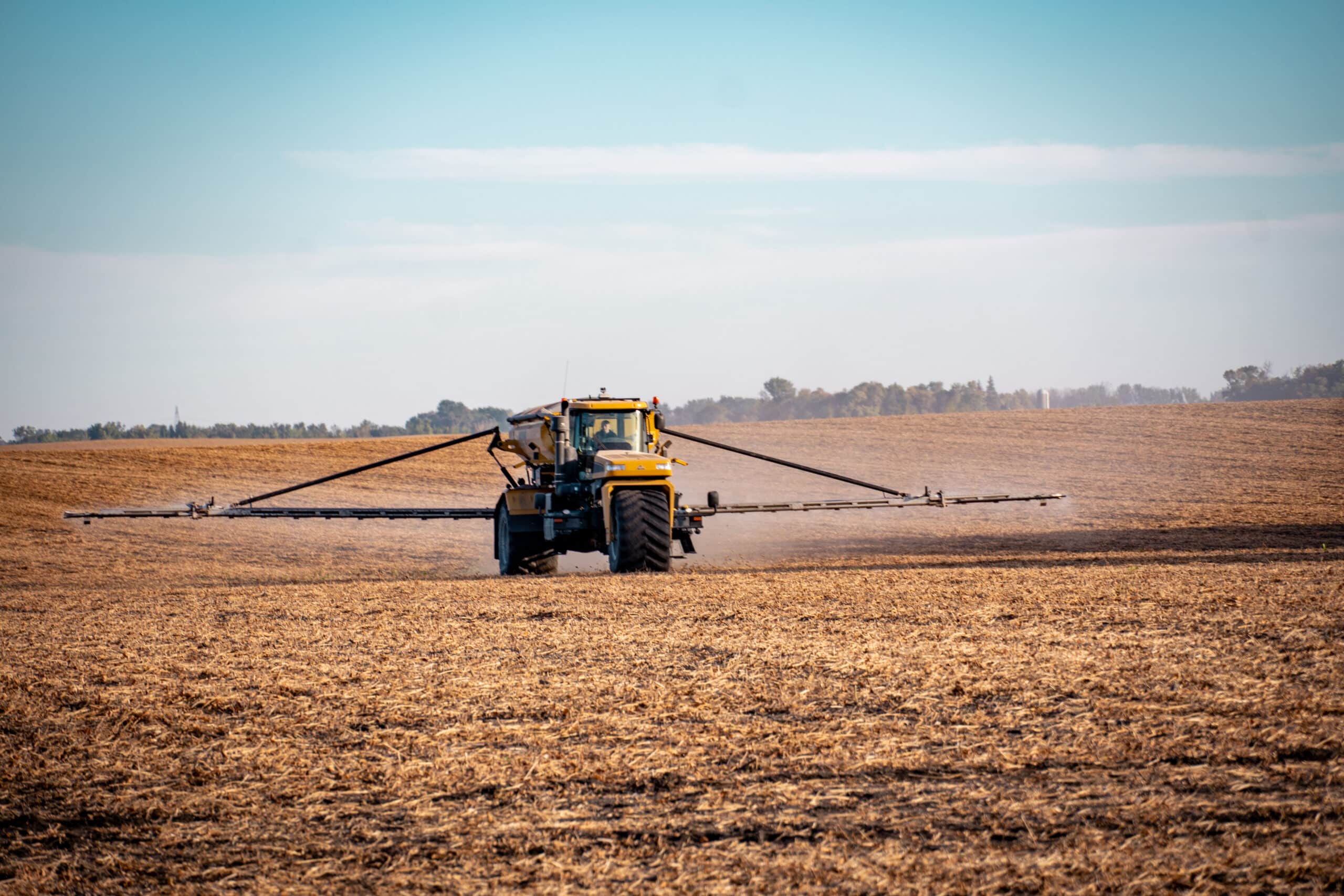 Sprayer applying fall fertilizer in a field