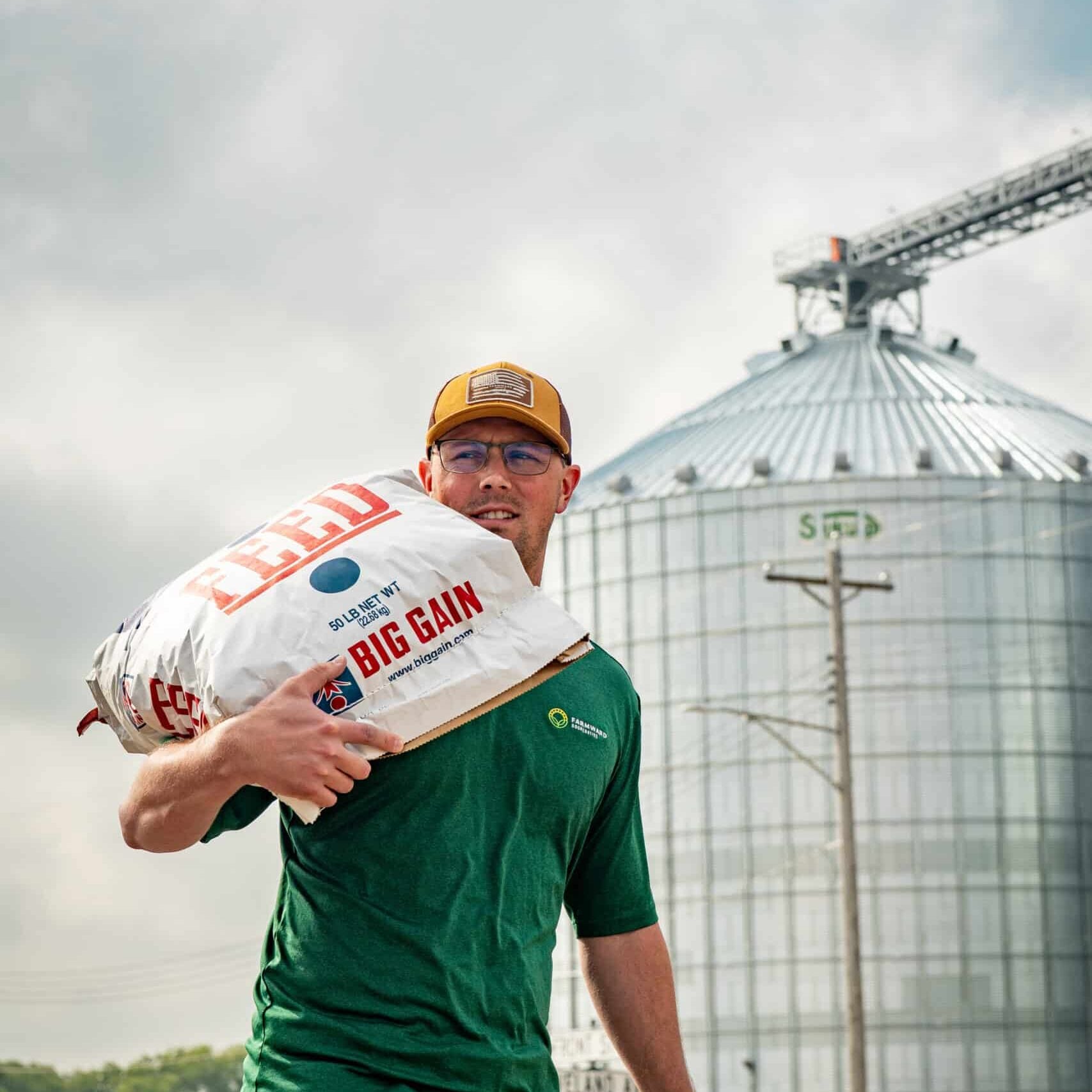 team member carrying feed bag on shoulder